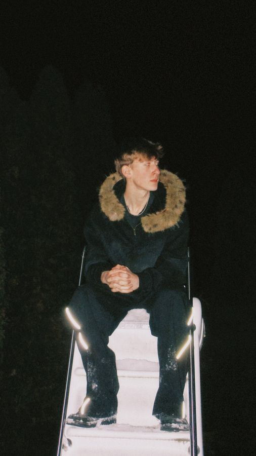 Sun Fade fur hoodie, seated at night